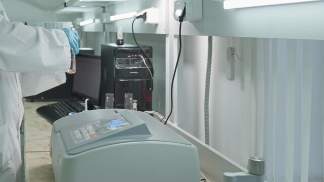 People work in a chemical laboratory. Protective clothing, equipment, bright lights.
