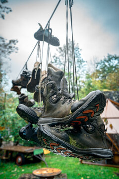 Worn hiking boots hanging representing concepts like the end of a journey, accomplishment, retirement, and a well-traveled life.