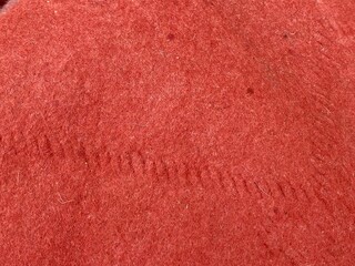 Red wool fabric texture featuring intricate stitched seam detail providing a soft cozy material surface perfect for winter clothing design and textiles backgrounds © Zahid