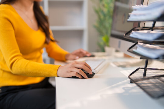 Woman's hand using computer mouse working from home