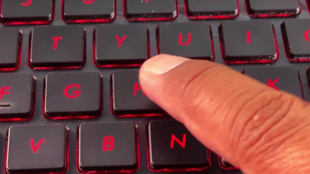 Finger pressing "H" keys on glowing keyboard, symbolizing fast typing, technology, and productivity.