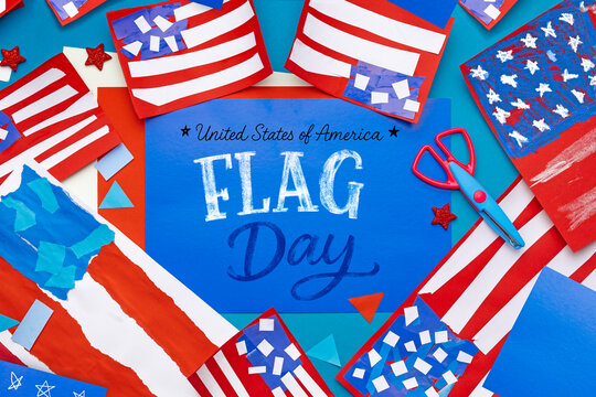 Colorful children&rsquo;s craft handmade paper USA flags, confetti and decorative elements on blue background. DIY patriotic activity for kids, school projects and Independence Day celebration, copy space.