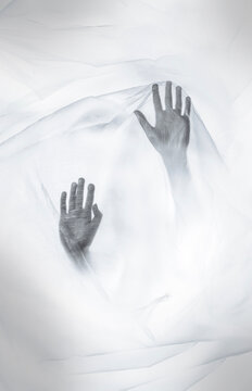 Silhouetted hands pressing against translucent plastic, symbolizing anxiety, panic, claustrophobia and psychological distress, mental health crisis and feeling trapped in isolation