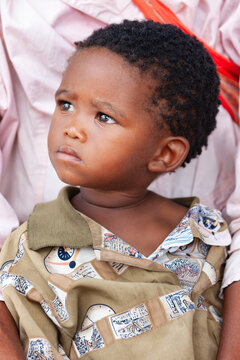 Young african Child in Rural Botswana in the Kalahari Desert held by his mother