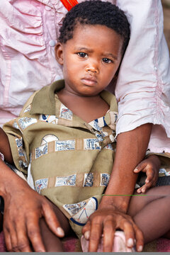 Young african Child in Rural Botswana in the Kalahari Desert held by his mother