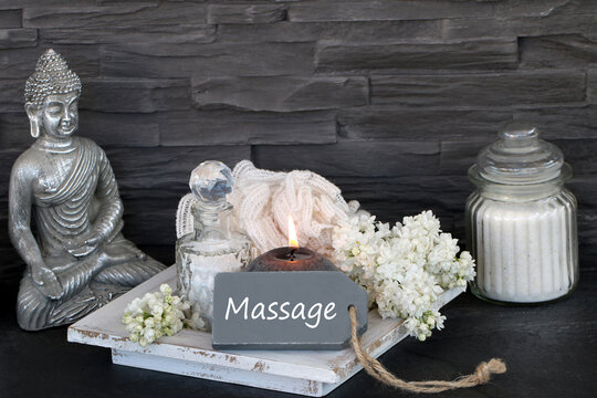 "Zen atmosphere in the spa: Silver Buddha with candlelight and wellness accessories in front of a slate wall."