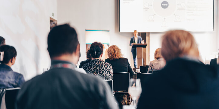 Speaker giving a talk in conference hall at business event. Rear view of unrecognizable people in audience at the conference hall. Business and entrepreneurship concept