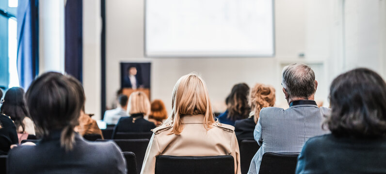 Speaker giving a talk in conference hall at business event. Rear view of unrecognizable people in audience at the conference hall. Business and entrepreneurship concept