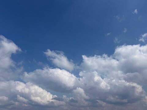 Cumulus fluffy clouds in the blue sky.