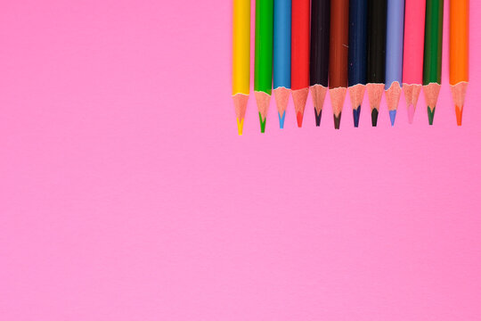 Upside down colorful pencils on pink background with copy space. Creative minimal design concept.
