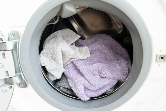 Close-up of clothes into a modern washing machine. Laundry day concept and household chores