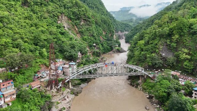 Majestic 4K Aerial Perspective of Trishuli River and Bridge in Lush Mountains