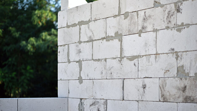 Unfinished walls made of white aerated concrete blocks. Construction site of a utility room under construction. Engineering technology, construction. Foam concrete block. work is underway block laying