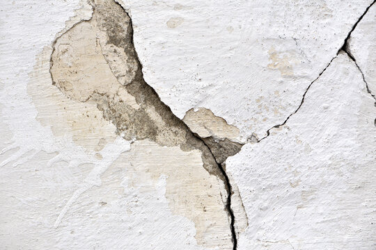 old plaster on the wall, cement, adhesive for screed. the old clay wall is crumbling. surface wall for vintage background. Wall texture, cracked plaster, grey cement floor, needs repair, restoration
