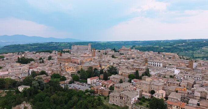 Orvieto Italy aerial view urban history. Ancient stone architecture cathedral hilltop town tuff rock. Summer vacation concept Italy tourism destination high angle drone shot exploration heritage.
