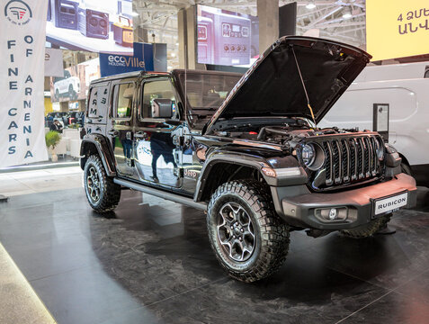 Black Jeep Wrangler with hood open, on indoor exhibition floor