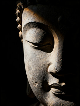 Close-Up Buddha Face with Dramatic Light and Shadow Spiritual Concept