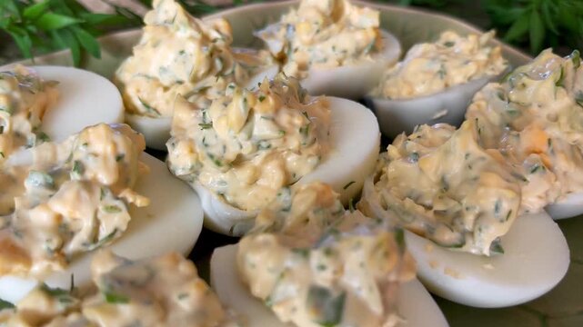 Homemade deviled eggs arranged on a leaf-shaped platter, styled as a rustic appetizer with creamy herb filling and cozy tabletop presentation.