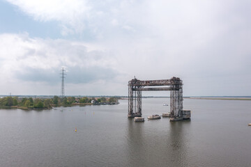 Naklejka premium Drone view of Hubbrucke Karnin on the Peenestrom near Karnin, Usedom, Mecklenburg-Vorpommern, Germany, with steel bridge remains, open water and soft spring light.