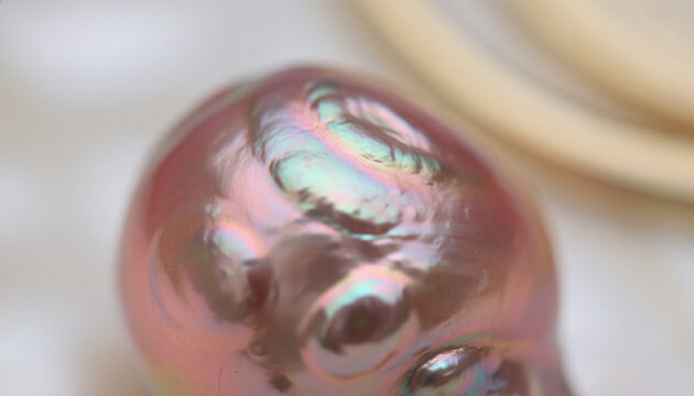 Natural Baroque pearl nacre texture with iridescent pink and green reflection