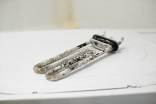 Washing machine heating element exhibiting severe limescale and burn damage