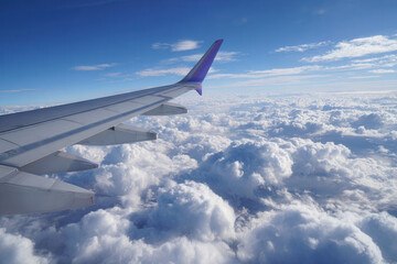 Obraz premium View from airplane wing over dense clouds during daylight sky