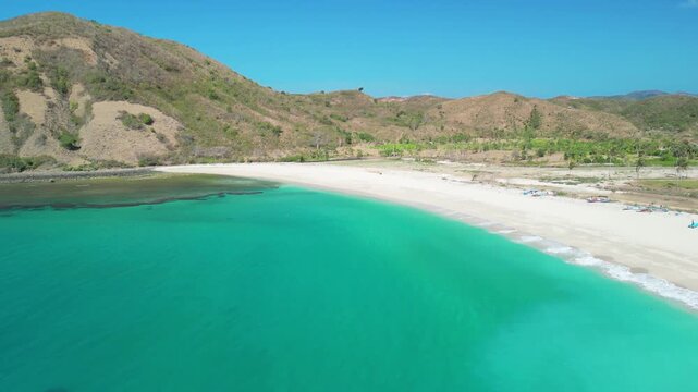 Stunning overhead panorama of Pantai Mawun near Kuta featuring calm lagoon fishing boats and pristine tropical shoreline
