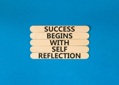 Self reflection symbol. Concept words Success begins with self reflection on beautiful wooden sticks. Beautiful blue background. Business success begins with self reflection concept. Copy space.