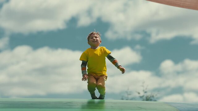 Happy little boy jumping on trampoline