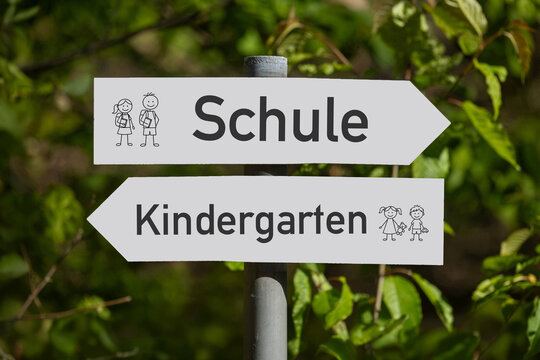 Schilder im Wald mit hinzugef&uuml;gtem Text SCHULE und KINDERGARTEN