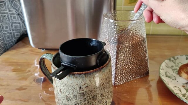 Ground coffee is poured into a coffee filter on a cup