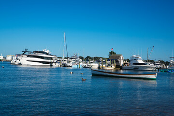 Fototapeta premium A serene scene of boats docked at a marina on a sunny day with a clear blue sky 