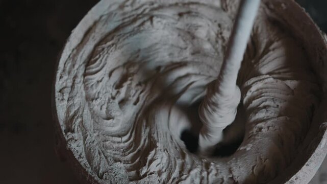 Mixing cement mortar in bucket with electric mixer close up