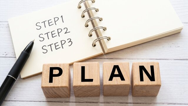ノートに書かれたSTEP1・STEP2・STEP3と木製ブロックのPLANが計画立案を印象づけるビジネスコンセプトイメージ。目標設定、行動計画、プロジェクト管理、学習計画、業務整理、ステップアップ、戦略設計などの広告や販促物に使いやすいシンプルなデスクトップ素材