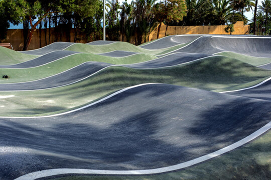Curved asphalt waves at outdoor pump track for extreme sports enthusiasts