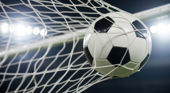 Soccer ball hitting the net in a dramatic night match