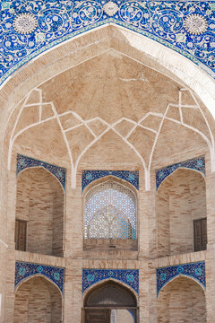 View of the intricate brickwork and blue mosaic tiles of the Kukeldash Madrasah in Tashkent, Uzbekistan.