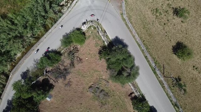 Aerial view of a large group of cyclists riding on a rural road in Mallorca during a bike race, Mediterranean landscape background.