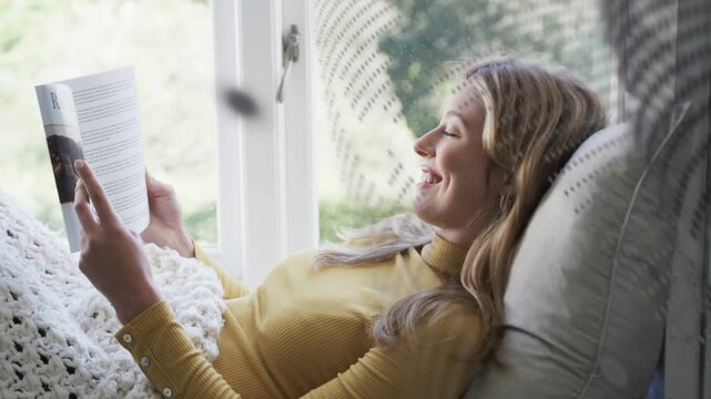 Woman on daybed turning pages and relaxing, revealing RACHEL, dotted curtain drifting, publishing