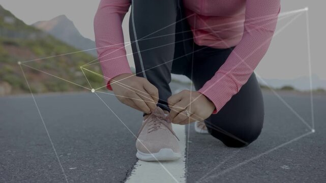 Runner kneeling on centerline tying laces tucking cuff prepping fitness with net overlay