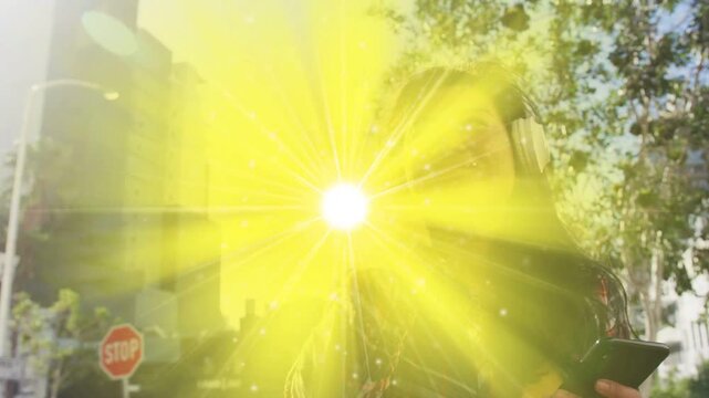 Woman walking scrolling phone for tech, flare rising and causing headset adjusting from sun glare