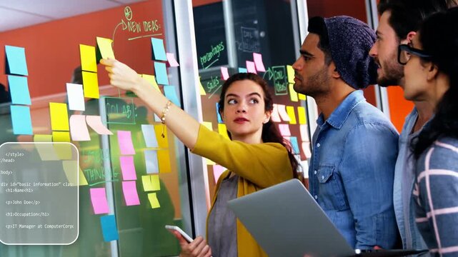 Facilitator placing sticky notes on glass for product planning session while code overlays shifting