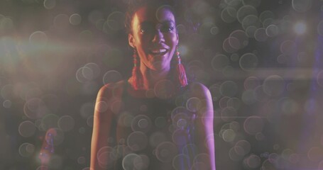 Fototapeta premium Singing singer center stage, wearing sleeveless top, red tassel earrings, mic, guitar, bokeh haze