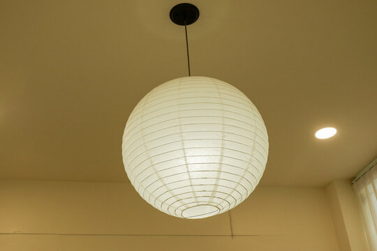 Traditional asian white paper lantern on the ceiling in living room at home,detail of white Japanese Paper lamps,mediterranean design,home interiors,Space for text..