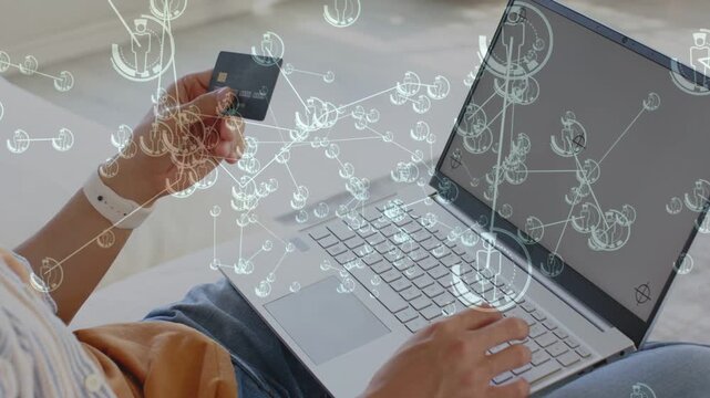 Man placing laptop, lifting card and turning chip while typing, overlay linking completing payment