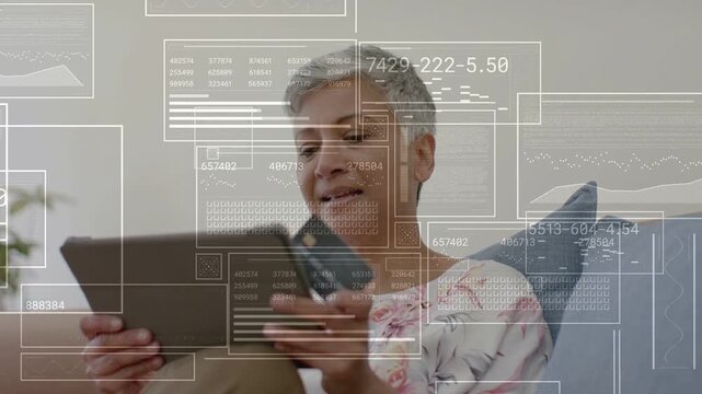 Senior woman tapping tablet holding card, activating finance HUD showing charts confirming payment