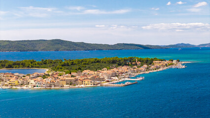 Fototapeta premium Aerial view of the picturesque island of Krapanj in Croatia with traditional stone houses and turquoise Adriatic Sea water on a sunny day