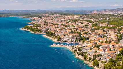 Fototapeta premium Panoramic aerial view of a coastal town in Croatia with red roof houses and turquoise Adriatic Sea