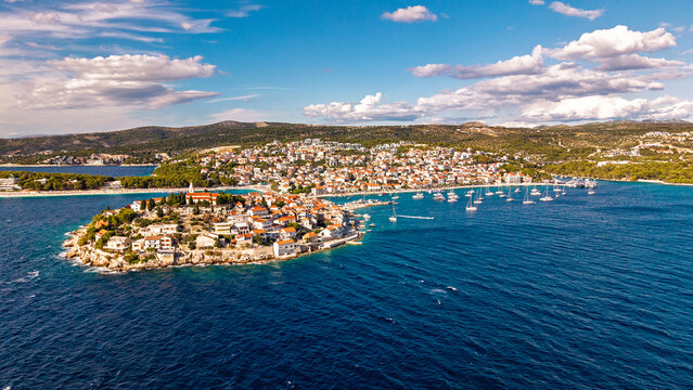 Aerial view of Primosten town on the Adriatic coast in Croatia with red roof houses and blue sea