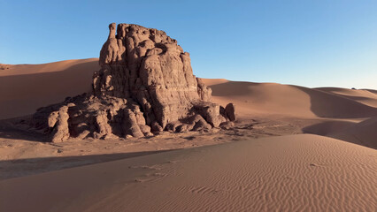 Fototapeta premium A trip to Sahara desert in Algeria. Beautiful african travel photo. Sandy landscapes, mountains, rocks, dunes, and nature. Summer vacation in arab country.